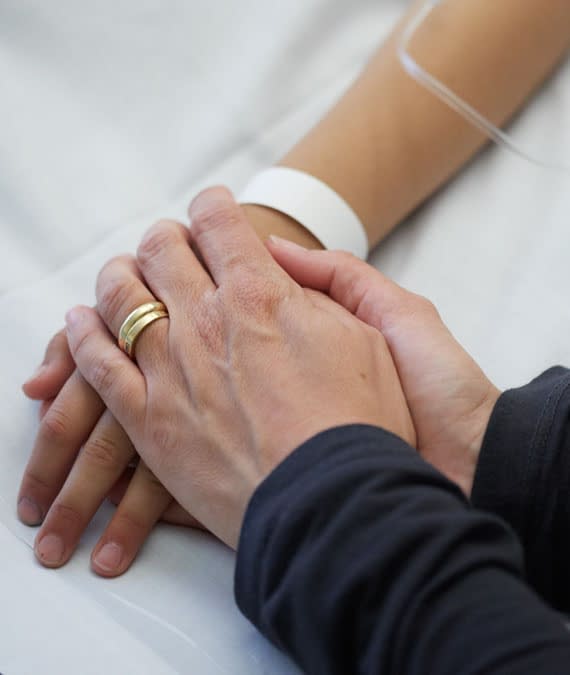 close up image of holding a patients hand